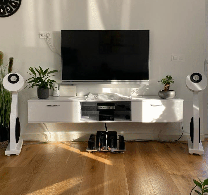 barber using styling spray on young man with black hair, short on sides and long in a quiff on top